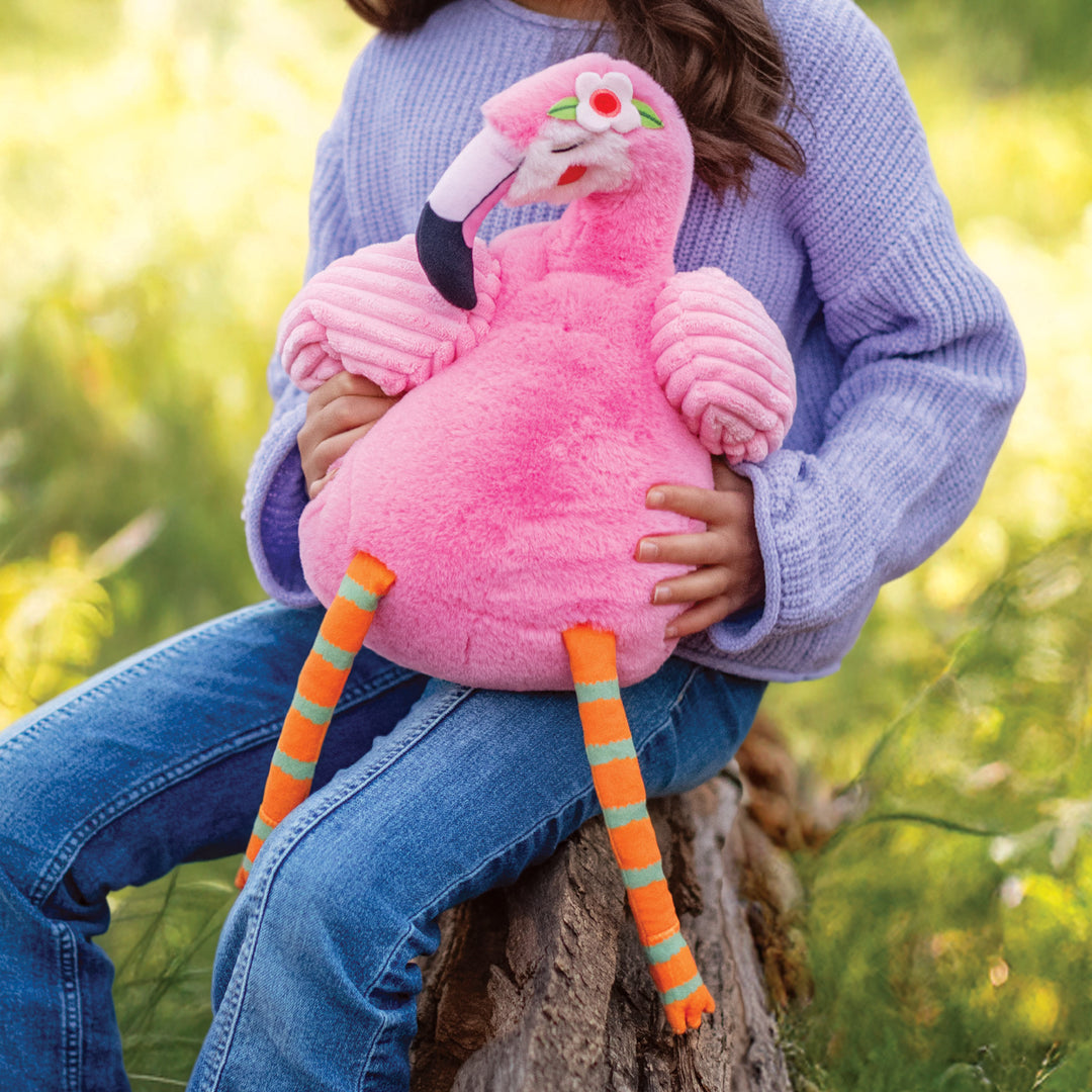 Person holding a pink plush flamingo toy outdoors