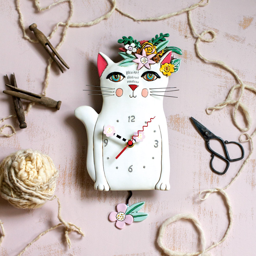 Cat-shaped clock with decorative elements on a textured surface